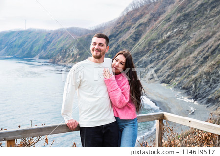 Young married couple hugging together and standing against japanese sea 114619517