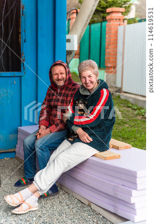 Mature russian married couple hugging and holding a dog 114619531