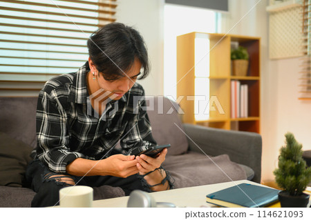 Young man browsing internet and texting online on mobile phone Young man browsing internet and texting online on mobile phone 114621093