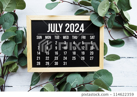 July 2024 monthly calendar with green leaf decoration on wooden background July 2024 monthly calendar with green leaf decoration on wooden background 114622359