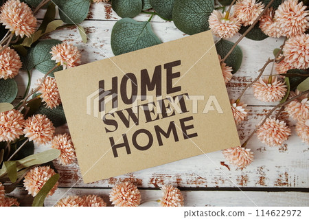 Home Sweet Home text message on paper card with flowers border frame on wooden background Home Sweet Home text message on paper card with flowers border frame on wooden background 114622972
