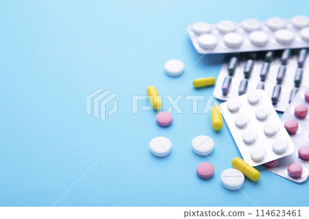 Colored pills and tablets in blister on a blue background, top view Colored pills and tablets in blister on a blue background, top view 114623461