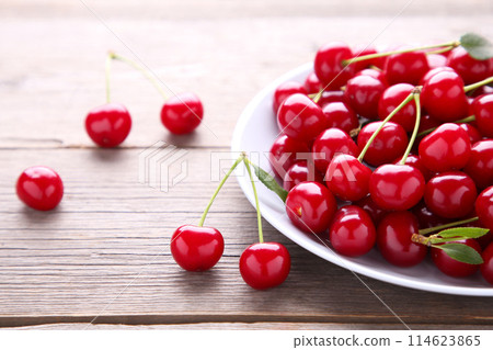 Fresh red cherry fruit in plate on grey wooden table Fresh red cherry fruit in plate on grey wooden table 114623865