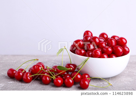 Fresh red cherry fruit in bowl on grey concrete background Fresh red cherry fruit in bowl on grey concrete background 114623898