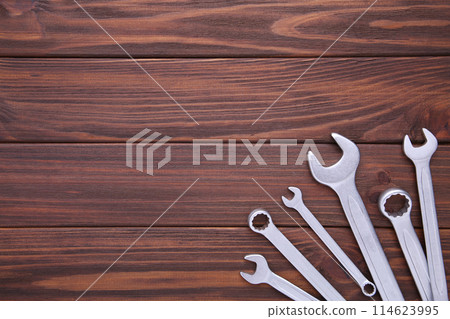 Combination wrenches for repair on brown wooden background 114623995
