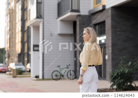 Young caucasian blonde woman strolling through the city in the summertime Young caucasian blonde woman strolling through the city in the summertime 114624043