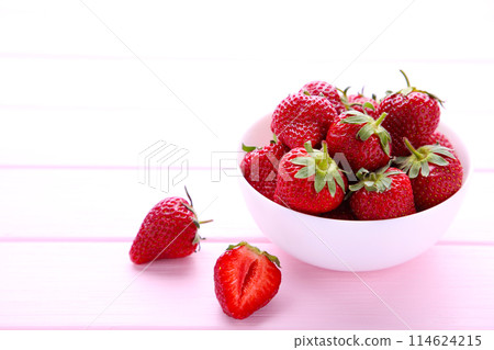 Strawberries in bawl on pink wooden background Strawberries in bawl on pink wooden background 114624215