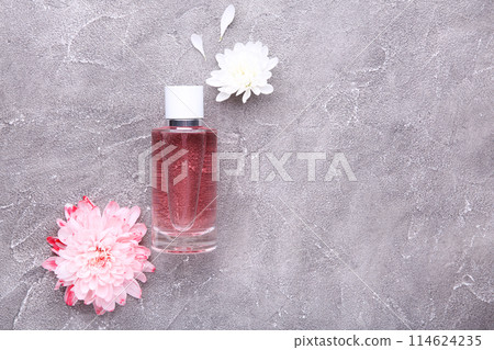 Perfume bottle with flowers on grey concrete background 114624235