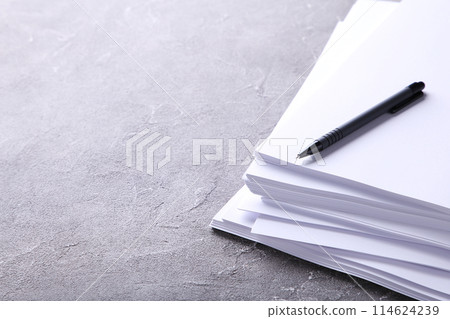 Stack white paper with pen on grey concrete background with Clipping Path Stack white paper with pen on grey concrete background with Clipping Path 114624239