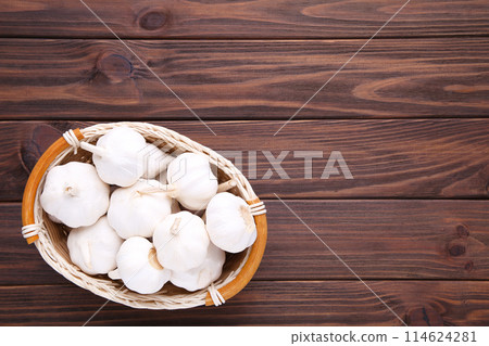 Fresh garlic in basket on a brown wooden background 114624281