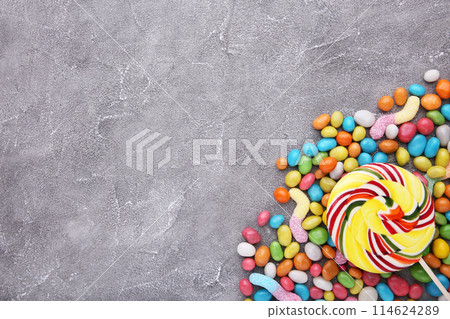 Colorful lollipops and different colored round candy on grey background 114624289