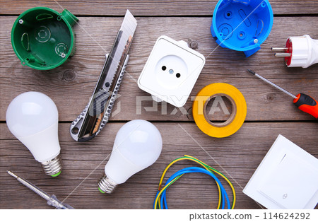Set of electrical tool on grey wooden background. Accessories for engineering work, energy concept. Set of electrical tool on grey wooden background. Accessories for engineering work, energy concept. 114624292