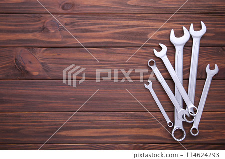 Combination wrenches for repair on brown wooden background Combination wrenches for repair on brown wooden background 114624293