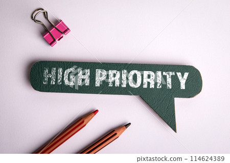 High Priority. Green speech bubble on white office desk 114624389