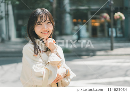 A young woman walking alone in the city on a holiday 114625084