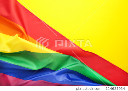 Rainbow LGBT flag on yellow background with copy space 114625934