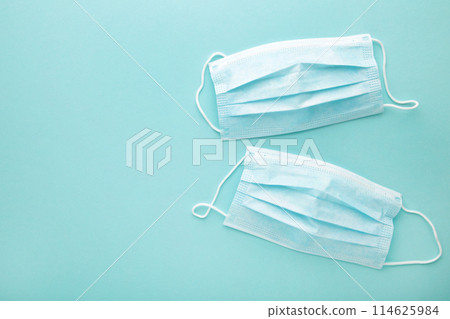 Medical used masks on a mint background with copy space. Coronavirus 114625984
