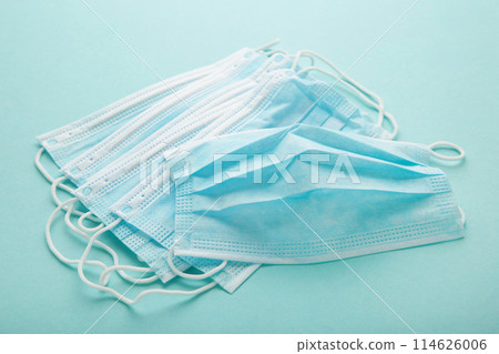 Medical masks on a mint background with copy space. Coronavirus 114626006