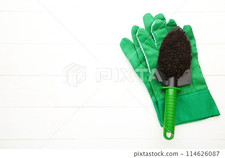 Green garden tools shovel with gloves on white background Green garden tools shovel with gloves on white background 114626087