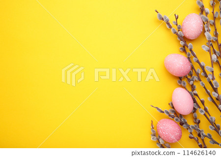 Pink easter eggs and willow branches on yellow background 114626140