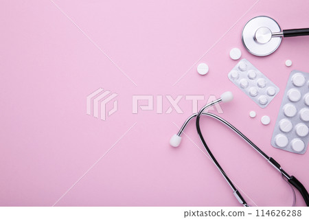 Stethoscope with white pills on pink background. Top view with place for your text. 114626288