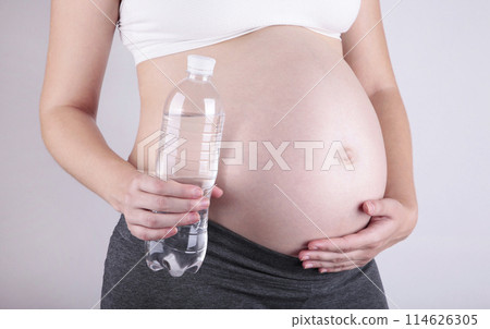Young pregnant woman holding a bottle of water Young pregnant woman holding a bottle of water 114626305