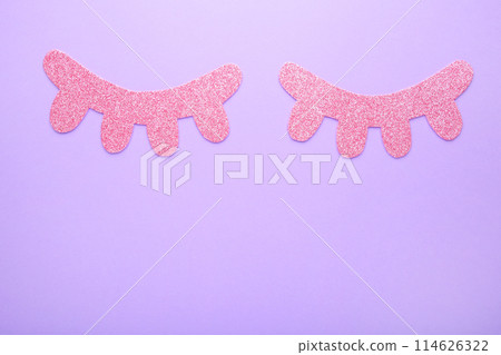 Glitter eyelashes on lilac background. Top view 114626322