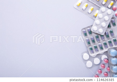 Colored pills and tablets in blister on a grey background, top view Colored pills and tablets in blister on a grey background, top view 114626385