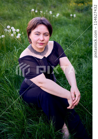 a    medium size woman in a black corset and wide leg trousers walks through the city in the morning light 114627432