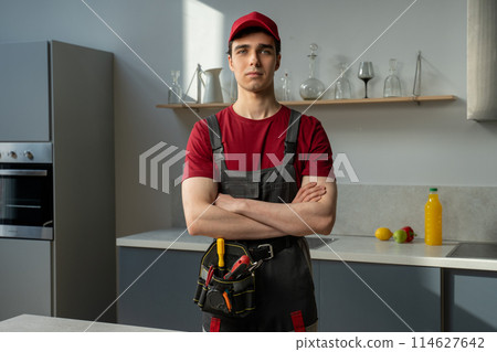 Young Male Technician With Tools Ready for Household Repairs in Modern Kitchen Young Male Technician With Tools Ready for Household Repairs in Modern Kitchen 114627642