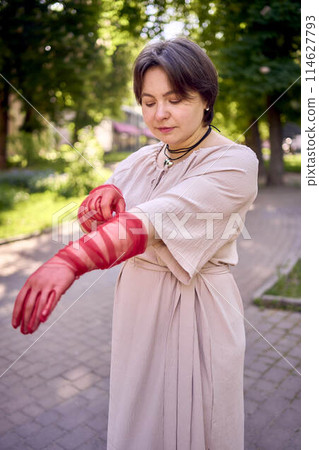 plus size woman in peach fuzz dress and red translucent gloves dancing in the morning city streets plus size woman in peach fuzz dress and red translucent gloves dancing in the morning city streets 114627793