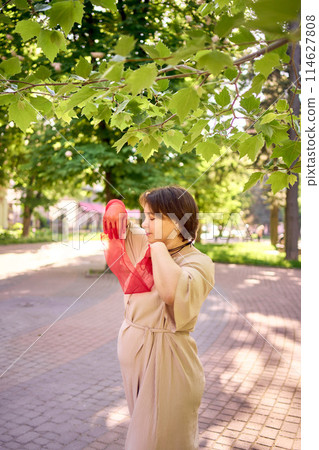 plus size woman in peach fuzz dress and red translucent gloves dancing in the morning city streets plus size woman in peach fuzz dress and red translucent gloves dancing in the morning city streets 114627808