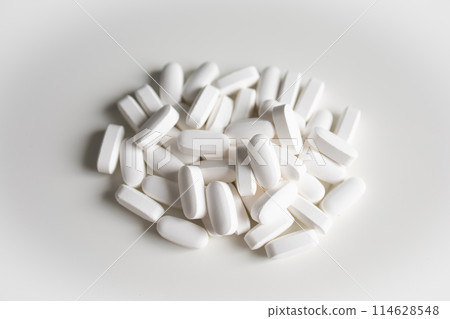 Big white pills on white background 114628548