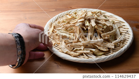 Dried daikon radish slices served on a colander (wood grain background) 114629437