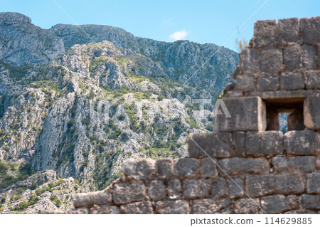 View from below of the old medieval ruined fortress of St. John in Kotor, Montenegro. Beautiful mountain landscape in background. Historic excursion at resort View from below of the old medieval ruined fortress of St. John in Kotor, Montenegro. Beautiful mountain landscape in background. Historic excursion at resort 114629885