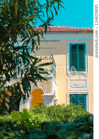 Beautiful Mediterranean house surrounded by plants and trees. Summer vacation in vintage hotel Beautiful Mediterranean house surrounded by plants and trees. Summer vacation in vintage hotel 114629895