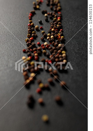 Colored peppercorns on a black background Colored peppercorns on a black background 114630153