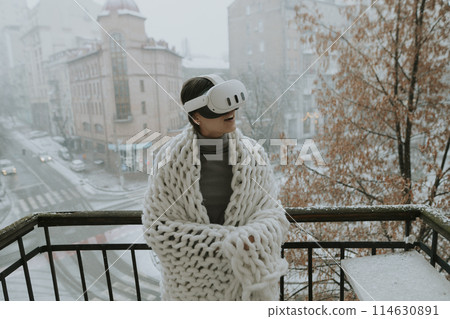 A captivating girl explores the virtual world against the backdrop of the winter city. 114630891