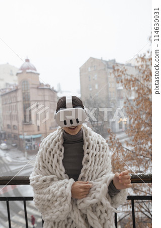 An enchanting woman in VR glasses gazes at the winter cityscape around her. An enchanting woman in VR glasses gazes at the winter cityscape around her. 114630931