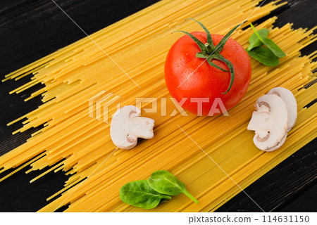 Spaghetti with tomato, mushrooms and spinach on black background. Top view. Healthy eating concept. Preparation of products. 114631150