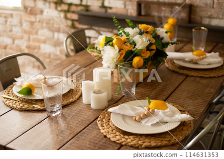 Summer table setting with wood furniture, cutlery and lemons 114631353