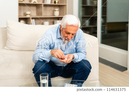 Middle aged senior man with medical pill and glass of water. Mature old senior grandfather taking medication cure pills vitamin. Age prescription medicine healthcare therapy concept Middle aged senior man with medical pill and glass of water. Mature old senior grandfather taking medication cure pills vitamin. Age prescription medicine healthcare therapy concept 114631375