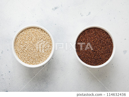 Two bowl plates with white and brown quinoa balanda grain seed on kitchen table. 114632436