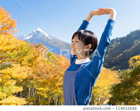 一個女人在秋葉的背景下伸展身體 114632688