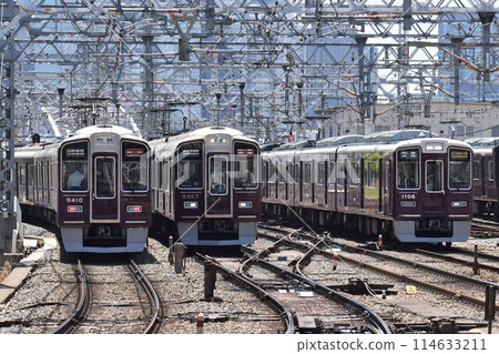 阪急電鐵栗色列車在三條雙軌上行駛 阪急電鐵栗色列車在三條雙軌上行駛 114633211
