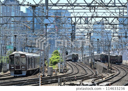 阪急電鐵栗色列車在三條雙軌上行駛 114633236