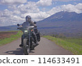 A motorcycle riding along the Tsumagoi Panorama Line with Mount Asama in the background 114633491