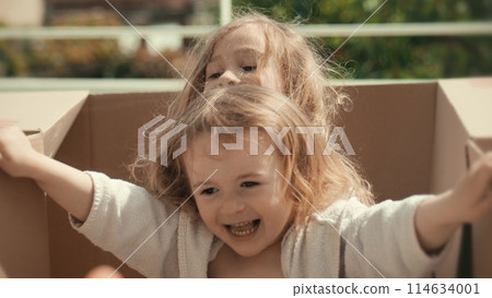 Little girls play with cardboard boxes. New home move or logistics concepts 114634001