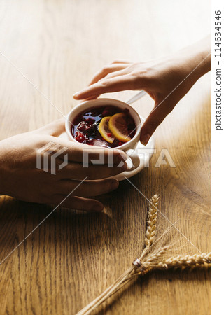 Male and female hand reaching for a cup of tea Male and female hand reaching for a cup of tea 114634546