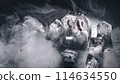 frozen rings in ice with water and smoke on black background	 114634550
